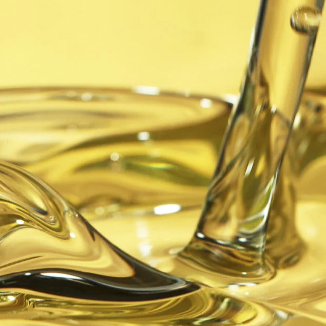 Detalle de aceite de oliva virgen extra con textura fluida y reflejos dorados
