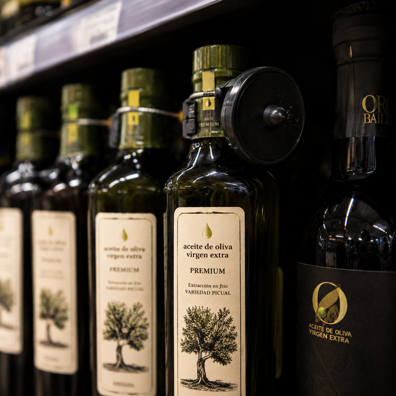 Botellas de aceite de oliva virgen extra premium en una estantería gourmet
