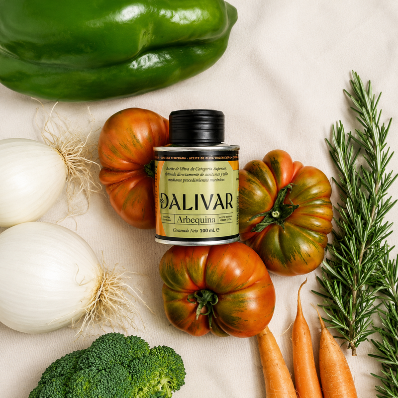 
                  
                    Aceite de oliva virgen extra DALIVAR Arbequina 100 ml con verduras frescas: tomates, cebollas, pimiento, zanahorias, brócoli y romero.
                  
                