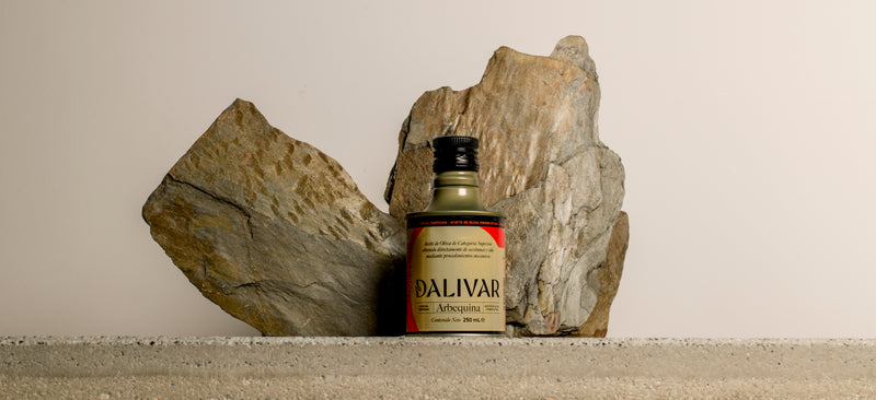 Botella de aceite de oliva virgen extra Dalivar Arbequina de 250 ml junto a piedras naturales
